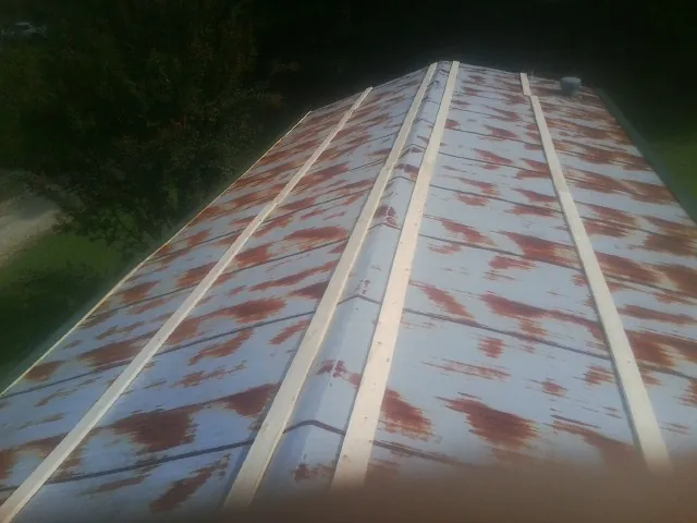 Rusted metal roof panels with new wood purlins before replacement — Storm Damage Roof Repair in Holly by Roofing Brothers