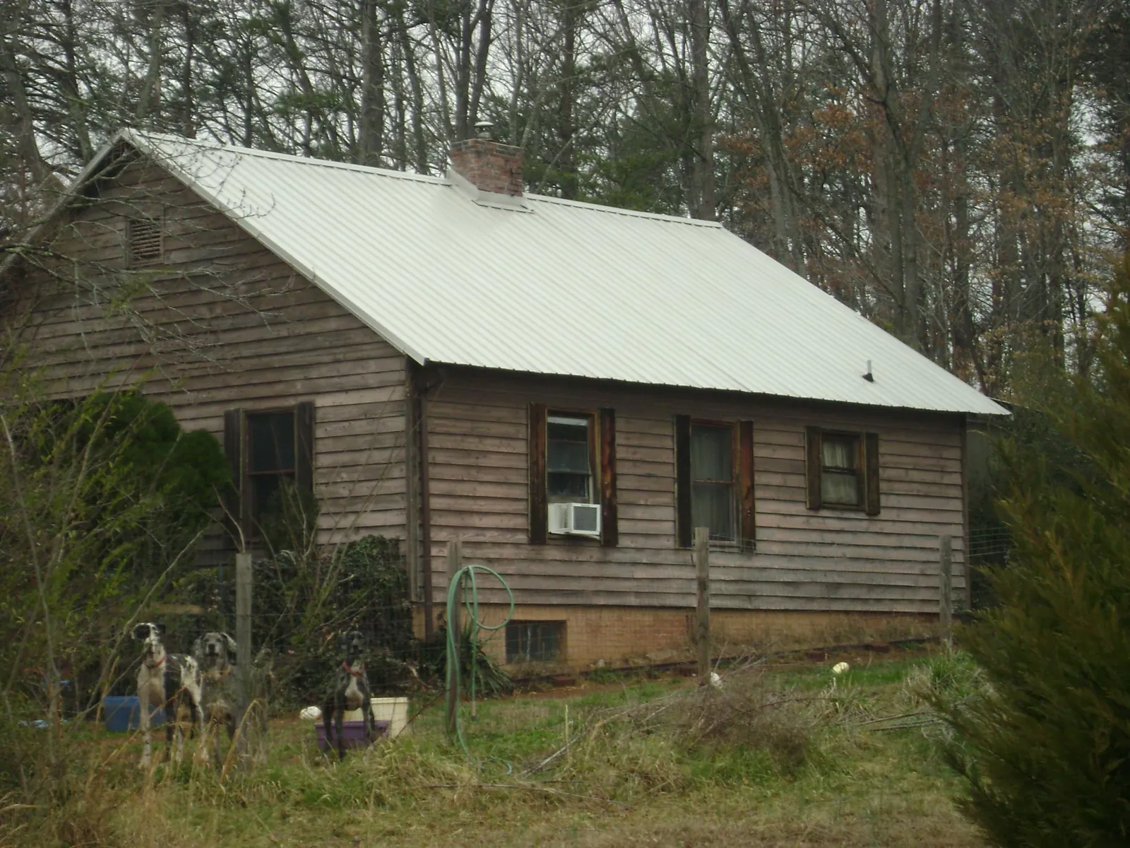 White metal roof on an old wood sided farmhouse, from a Metal Roof Installation job in Holly